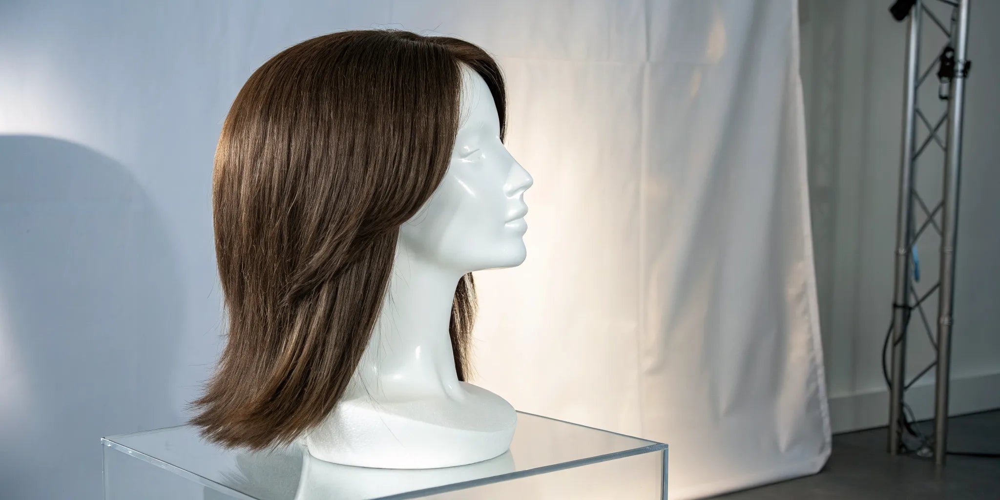 A medium-length brown wig with adjustable straps for a secure fit.