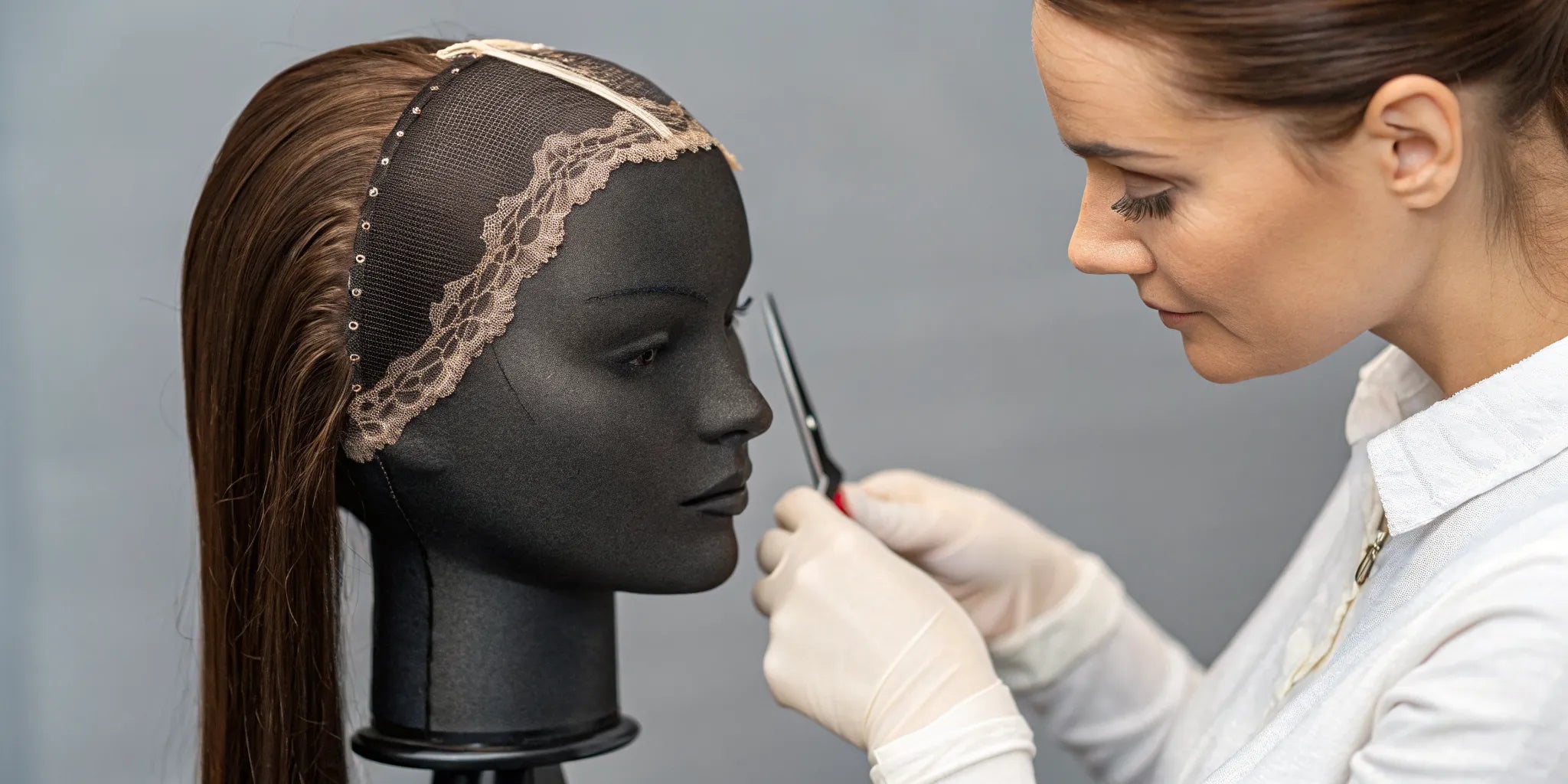 A professional customizes a wig by trimming the lace front for a perfectly natural hairline.