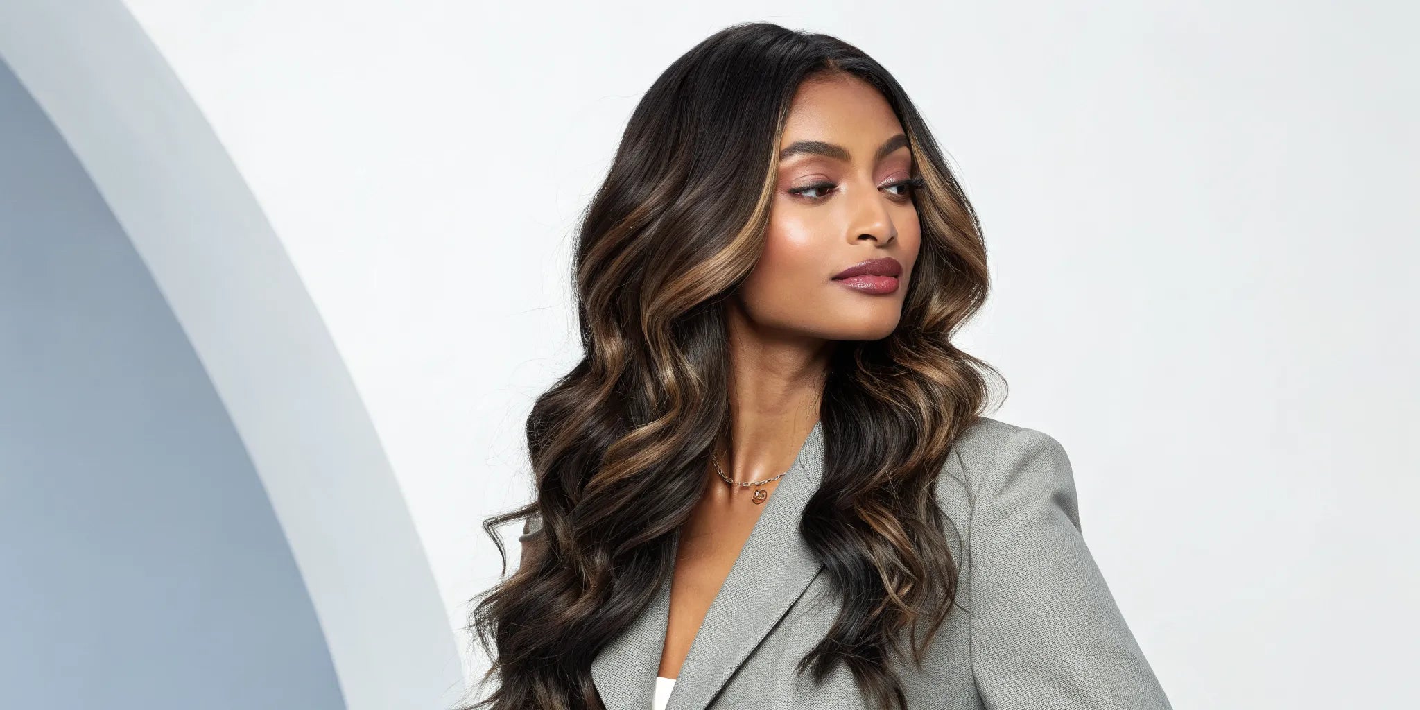 Woman wearing a long body wave human hair wig with highlights.