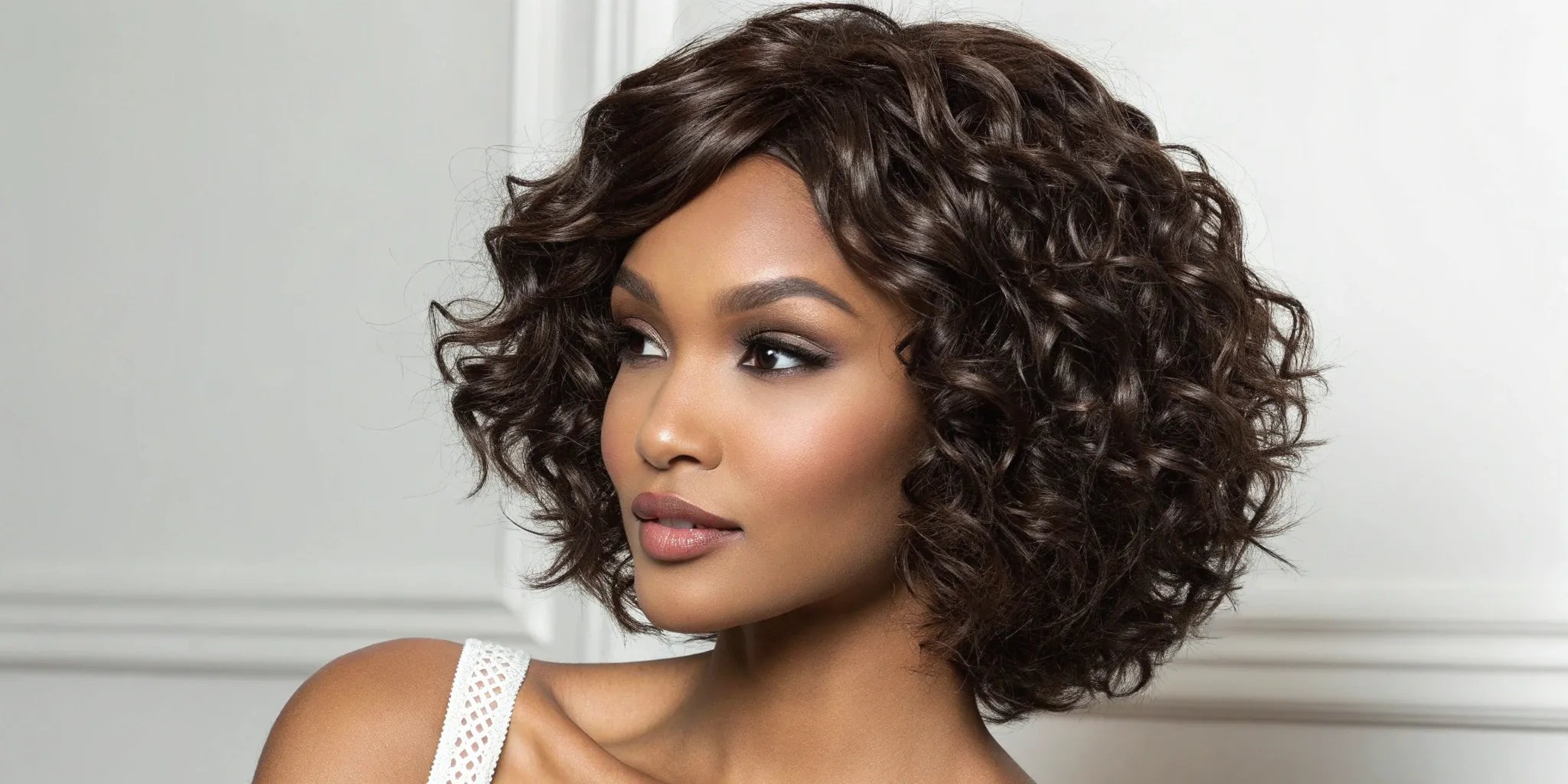 Woman wearing a short deep wave wig with defined, voluminous curls.