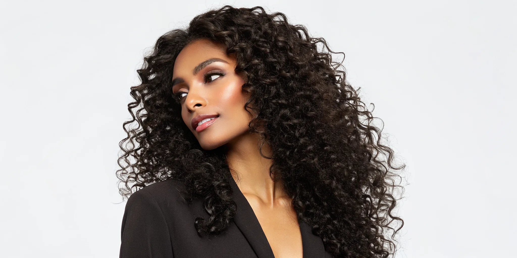 Woman wearing a deep wave human hair wig with defined waves and a natural shine.